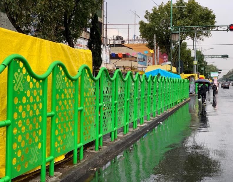 Valla perforada verde en vía pública